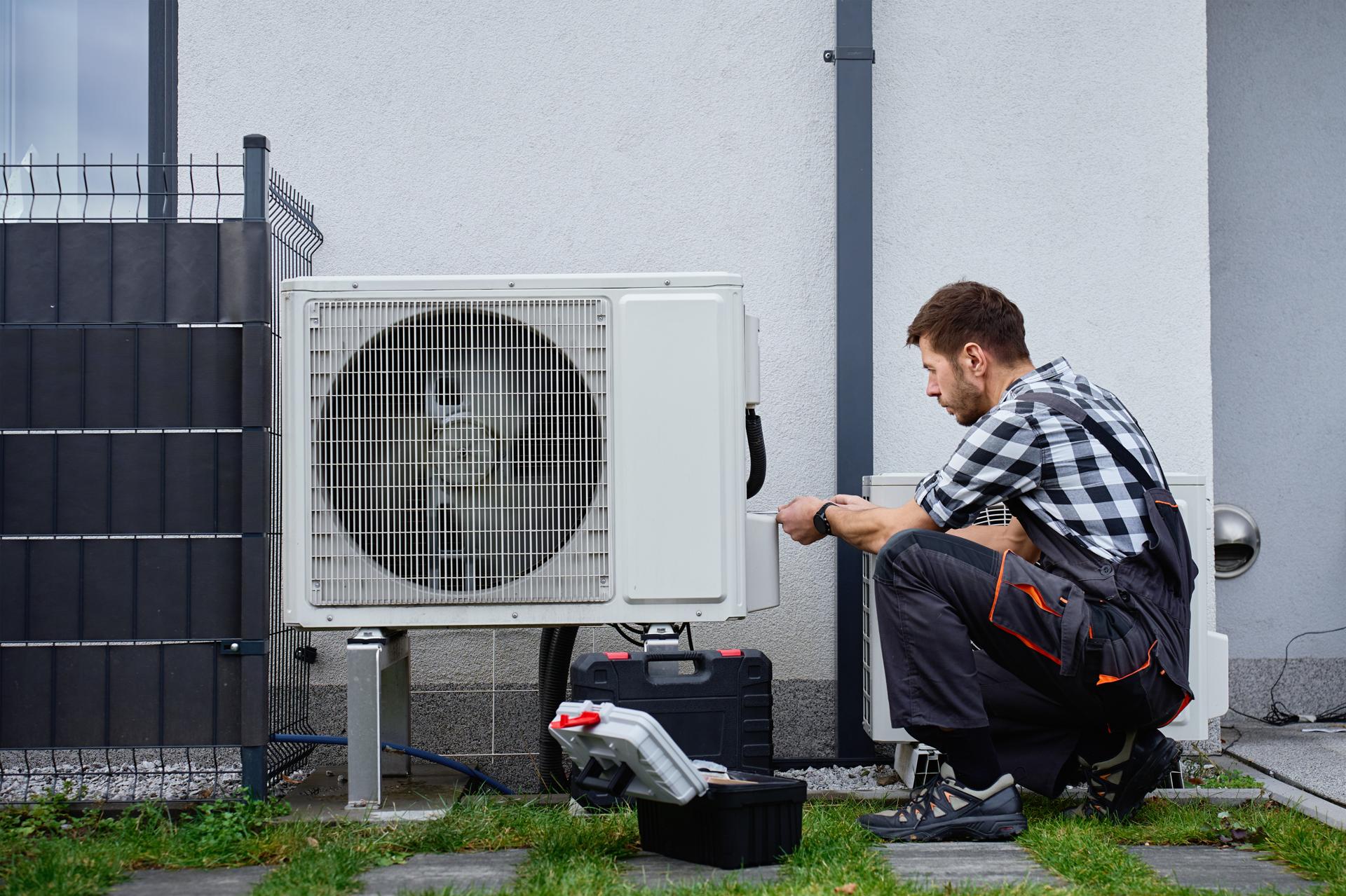 Technician servicing an outdoor condenser unit